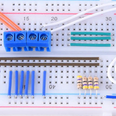 Close-up of a breadboard with blue connectors and resistors from 560 Piece Jumper Wire Kit With 14 Lengths Of Assorted Preformed Breadboard Wires.