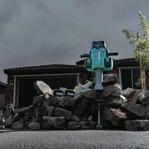 Badass Heavy Duty Eighty Volt Brushless Cordless Breaker Hammer With Seventy Foot Pounds Of Knockout Chisel Power and One One Eighth Inch Hex Shank AVT Anti Vibration AWS Compatible Demolition Kit featuring a heavy-duty hammer positioned on a pile of concrete rubble.