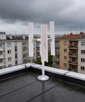 Vertical Wind Turbine Generator Kit 12V with 3 blades installed on rooftop against cloudy sky