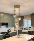Three Light Mid Century Modern Pendant Light Fixture With Gold Finish Glass Globe And Adjustable Cage Hanging Chandelier in kitchen