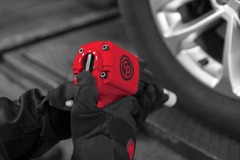 Mechanic using CP7741 Half Inch Air Impact Wrench With Twin Hammer Power for auto repair on vehicle wheel.