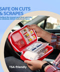 Person holding first aid kit open in car showing antiseptic towelettes for minor cuts, next to medical supplies and instructions.