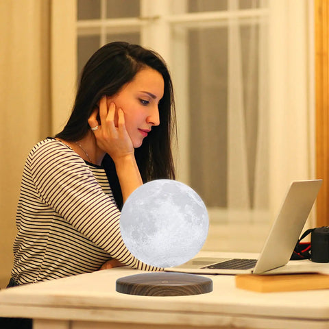 Dope Levitating Moon Lamp With Magnetic Floating Base, 3 Color Modes, on desk with woman using laptop in home workspace