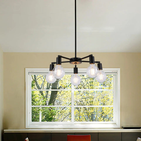 Five Light Modern Sputnik Chandelier in matte black over dining table with window background.