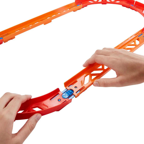 Hands assembling orange track from Track Builder Unlimited Playset Premium Curve Pack With 16 Component Parts And 1 64 Scale Vehicle.