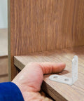 Hand holding a wooden shelf with Beefy Heavy Duty L Brackets Set With Screws, 16 Pack Cold Rolled Steel Corner Brackets for support