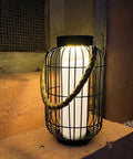 Big Solar Powered Lantern for Outdoor Use Heavy Duty Metal Hanging Lights with rattan handle on stone ledge at night
