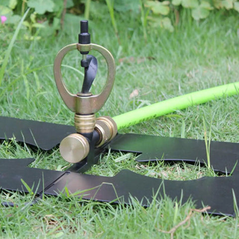 Real Deal Rooftop Sprinkler Offering 360 Degree Rotating Spray Pattern for lawn irrigation on grass with metal base and green hose.