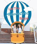 Epic 78 Inch Hot Air Balloon Photo Booth Frame Travel Theme Selfie Prop Great For Kids Birthday Parties Baby Showers Graduation And Back To School Classroom Decor Or Any Photo Backdrop with "Let the Adventure Begin" text and students in basket.