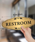 Hand holding Gold Brushed Restroom Sign Sticker For Business And Home Self Adhesive Waterproof Bathroom Door Sign Unisex