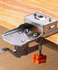 Montesy 35mm hinge drilling jig, stainless steel with orange adjustment knob, mounted on wood edge.