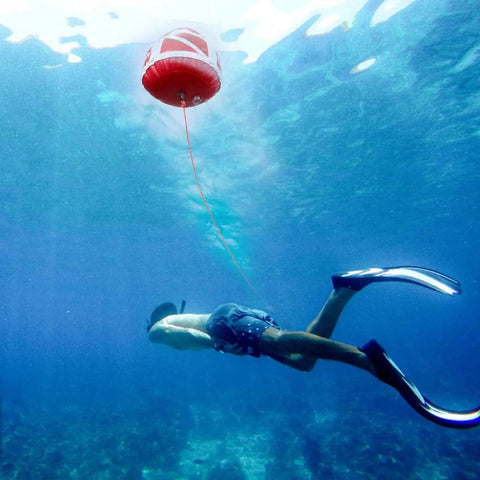 Snorkeler beneath the Red Dive Flag Inflatable Surface Marker Buoy For Scuba Diving Spearfishing And Boating with rope attachment