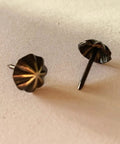 Close-up of Premium 7/16 Inch Upholstery Tacks For Furniture Fix Ups, sleek matte black decorative nailheads.