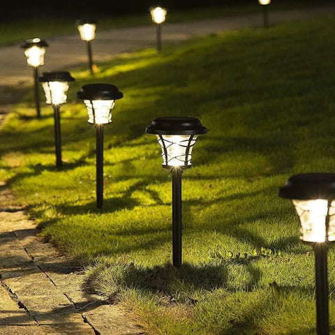 Six Pack Solar Pathway Lights Outdoor Waterproof Garden Lights with Metal and Glass Warm White LED illuminating a lawn