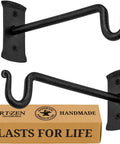 Heavy Duty Wrought Iron Plant Hanger Set Of Two For Indoor Or Outdoor Use Metal Wall Bracket Hooks To Hang Plants Baskets Lanterns and Bird Feeders Classic Black Shepherd Hook Style 7.5 Inch displayed with packaging box.
