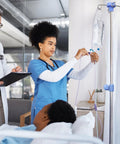 A nurse adjusts an IV on a Heavy Duty Stainless Steel Rolling IV Pole Stand With Built Tough Four Prong Holders And Quick Glide Casters.