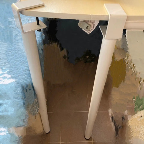 Slick Clamp On Adjustable Table Legs installed on a desk, showcasing the clamp mechanism and white metal legs.
