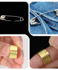 Safety pins on denim and fingers demonstrating needle thread guide features for quick fixes in sewing projects.