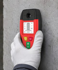 Hand holding a Stud Finder 6-in-1 Wall Scanner Metal Detector Live Wire(Red) on a concrete wall.