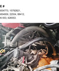 Engine lower heater hose outlet coolant recovery pipe in engine bay; orange engine block and black hoses visible