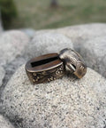 Antique Copper Tsuba And Fuchi Kashira Menuki Set For Samurai Sword Koshirae on rocks, detailed Japanese armor ornament.