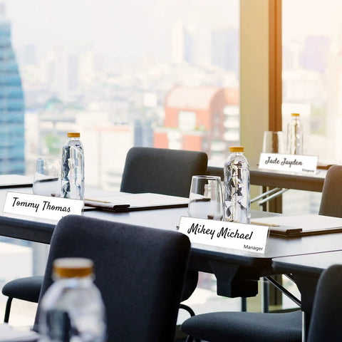 24 Pack Acrylic Name Plates For Desk 2x8 Inches Clear Slant Back Sign Holders on conference table with water bottles