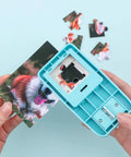 Hands using 1 Inch Puzzle Hole Puncher For DIY Jigsaw Crafts Portable Cardboard Cutter on photo to create custom puzzle pieces