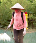 Person using agricultural knapsack sprayer in field