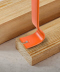 Orange claw bar from Four Piece Flat Pry Bar Set with 5.5 Inch, 7.5 Inch, 9.5 Inch, and 15 Inch in use on wooden board