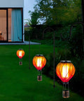 Colorful Solar Hot Air Balloon Lantern With Realistic Flickering Flame For Outdoor Waterproof Hanging Light For Patio Porch Yard Garden Decor Eco Friendly Solar Powered Garden Decor Lighting For Nighttime Vibe Ambience And Easy Dusk To Dawn Operation glowing in garden at dusk