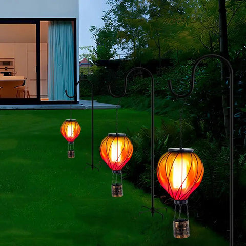 Colorful Solar Hot Air Balloon Lantern With Realistic Flickering Flame For Outdoor Waterproof Hanging Light For Patio Porch Yard Garden Decor Eco Friendly Solar Powered Garden Decor Lighting For Nighttime Vibe Ambience And Easy Dusk To Dawn Operation glowing in garden at dusk
