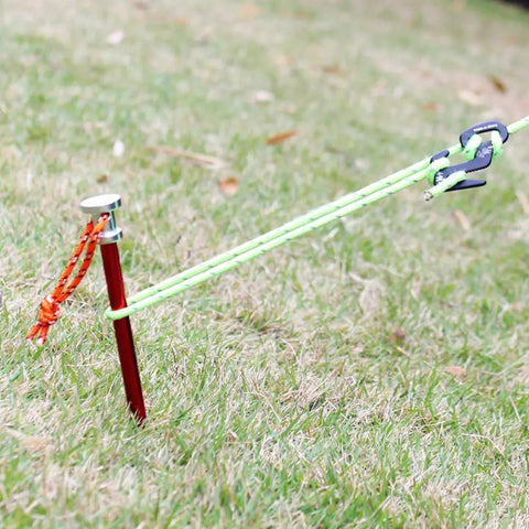 9 Inch Tent Stakes Set Lightweight Aluminum Alloy Ground Pegs for Outdoor Camping secured in grass with ropes