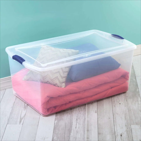Massive 105 Quart Clear Plastic Storage Bin With Heavy Duty Latch Lid Big Boy Stackable Box For Bedding Closet Camping, filled with blankets and pillows.