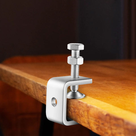 Installed front view of a 1-inch stainless steel mini C-clamp gripping a wooden workbench edge.