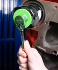 Hand using adjustable oil filter wrench for three and one eighth to three and seven eighth inch filters on car engine.