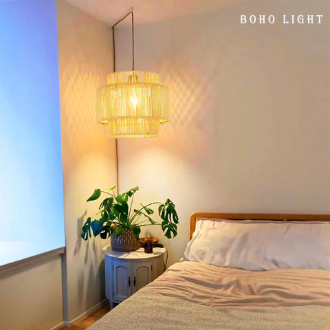 Plug In Pendant Light With Smooth Dimmable Switch And Handwoven Boho Rattan Shade over a cozy bedroom nightstand with plants.