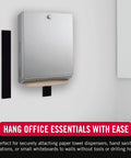 Stainless steel wall-mounted paper towel dispenser with brown paper towel protruding.
