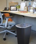 Durable 41 Quart Stackable Wastebasket Trash Can In Black, Heavy Duty Plastic With Rolled Rim For Easy Cleaning next to desk