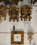 Wall display of vintage-style cuckoo clocks with wooden design and intricate pendulum, showcasing decorative living room accents.