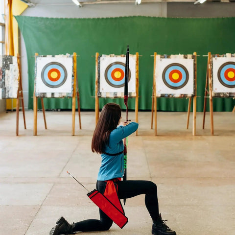 Person aiming at targets with Archery Target Paper Set For Backyard Practice And Hunting, indoor setup with target faces visible.