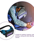 Person wearing Boss Grade Auto Darkening Welding Goggles Heavy Duty Industrial Safety Glasses With Lightning Shade Switch For Grinding Soldering And Precision Steel Fabrication In Navy Blue while welding.