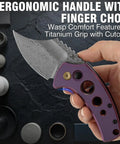 Hand holding Wasp Pocket Folding Knife With 2.36 Inch Modified Wharncliffe Blade, purple anodized titanium handle with holes