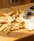 Assorted Wood Dowels Set, Fifty Pcs, Hardwood Dowels In Three Sixteenth Inch, Quarter Inch, with hammer and blueprint on workbench.