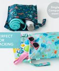 Super Handy Waterproof Wet Bag Two Pack For Travel And Beach with colorful prints, filled with accessories, towels, sunglasses.