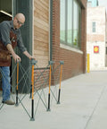 Man setting up Beefy Folding Work Table Centipede Saw Horse Stand 2 Ft Long By 4 Ft Wide By 2.5 Ft High Steel 1500 Lb Capacity
