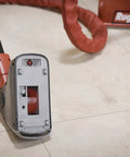 Motorized Grout Cleaning Tool For Deep Carpet Cleaners with attachment showing 1-inch grout line guides on tile floor