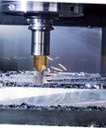Steel chamfering cutter with hex shank installed in a milling spindle, cutting metal with chips.
