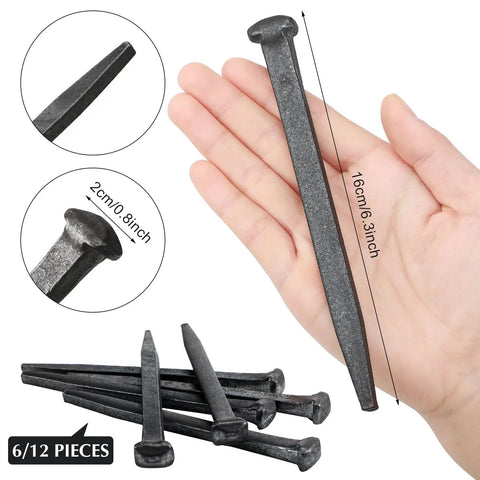 Hand holding six-inch crucifix iron nail with flat head, showing size and detail; heavy metal sacred ornaments, 6 pc Easter decor.