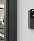 Black smart wifi thermostat with Alexa and HomeKit geofencing capable, wall-mounted in modern dining room setting with decor-snap covers.