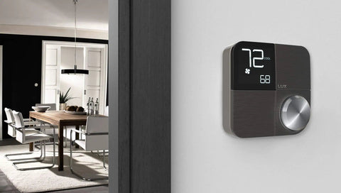 Black smart wifi thermostat with Alexa and HomeKit geofencing capable, wall-mounted in modern dining room setting with decor-snap covers.